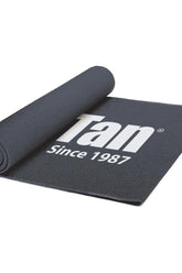 Pro Tan competitor mat, rolled up, featuring logo since 1987, ideal for competitions and workouts.